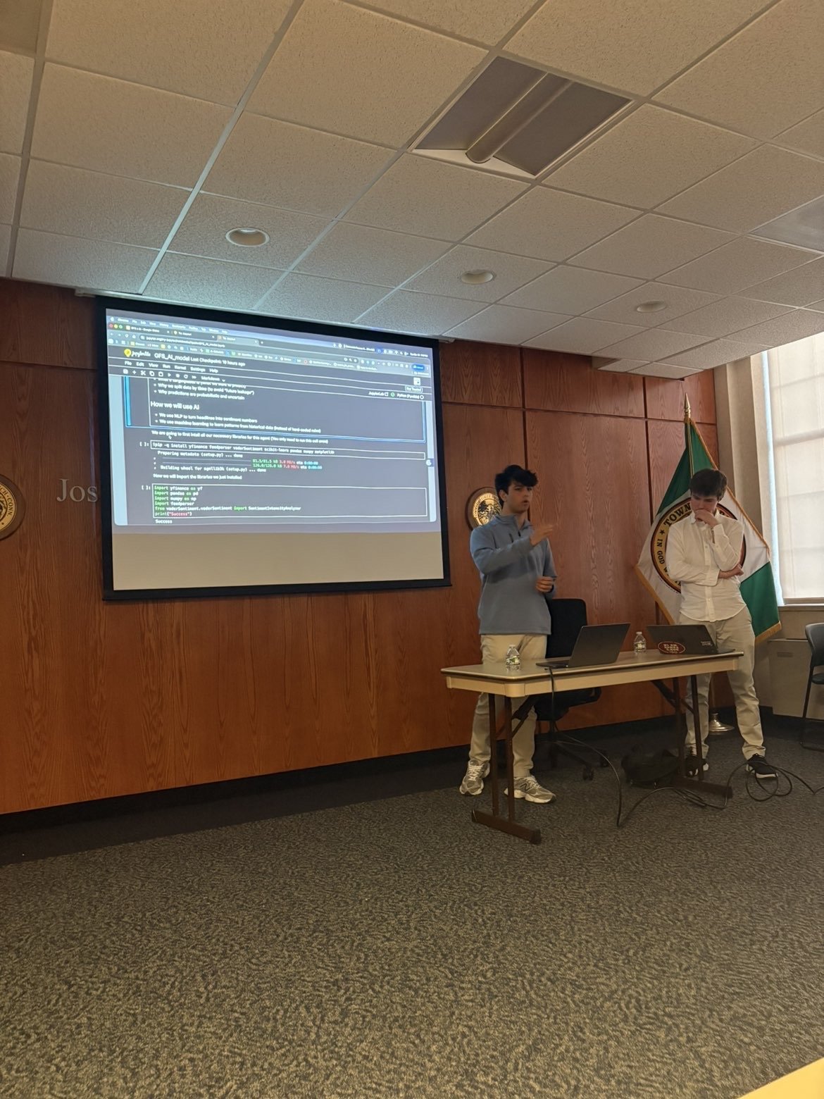 The Google Colab notebook projected full screen while a student presenter explains the code cells